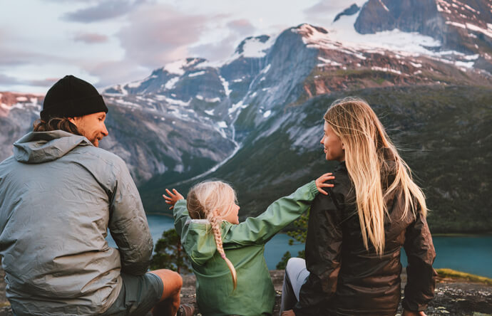 Man and woman sitting on mountain with child