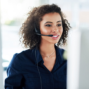 Customer service representative using headset and microphone to handle calls on laptop