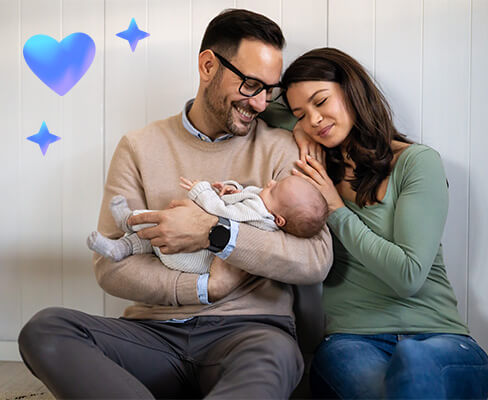 A blissful moment captured: new parents smiling with their baby nestled in their arms