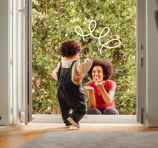 a toddler dashes towards their mom with a wide grin, ready for a hug