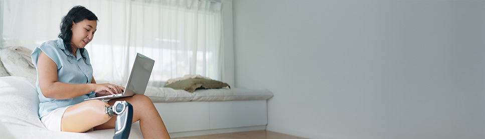 Woman typing on a laptop from the couch