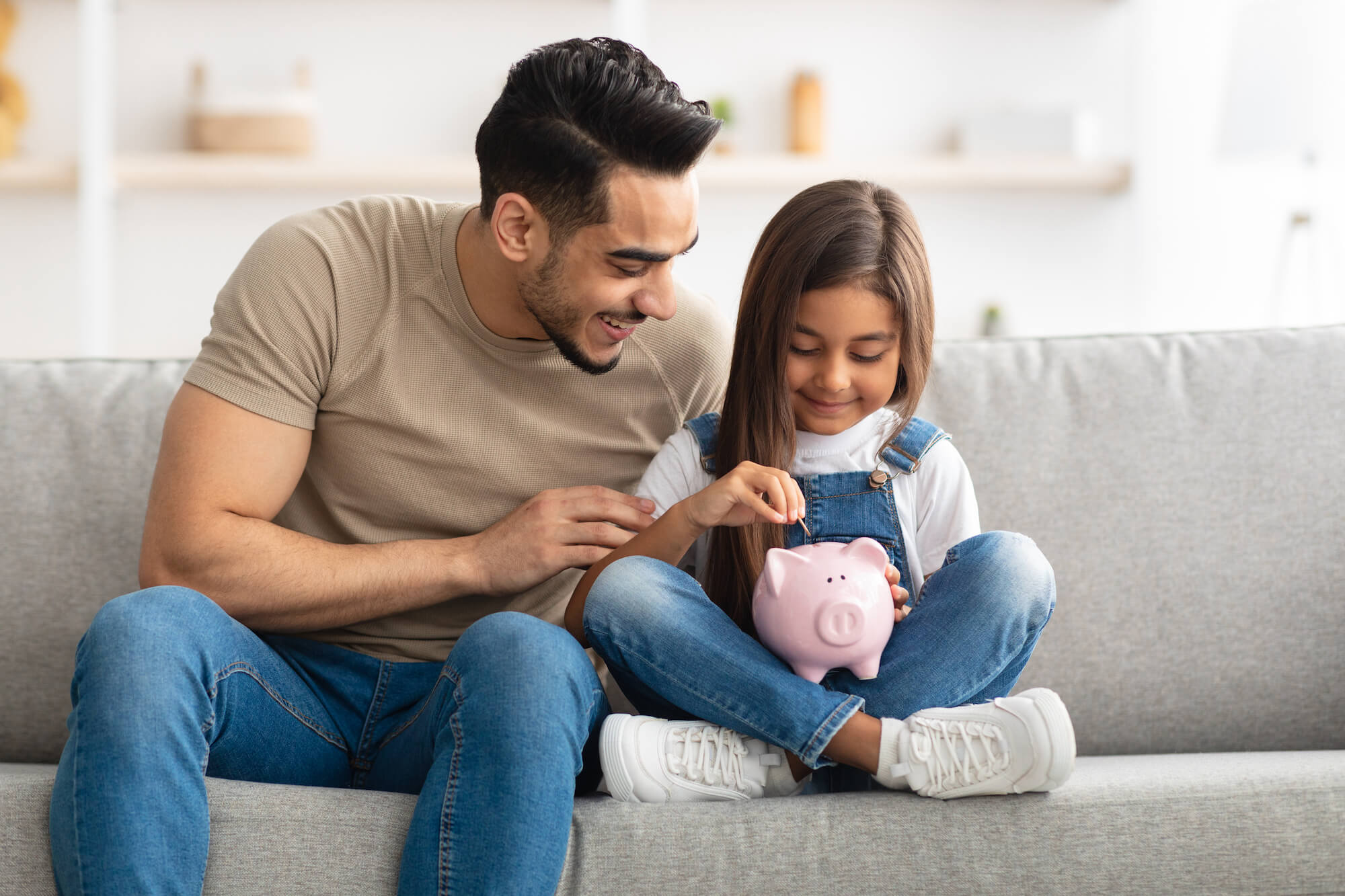Tax Benefits Page.jpg (Little girl and dad saving money in piggy bank)