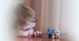 Boy playing with airplane toy.