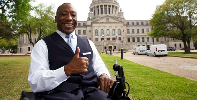 Man sitting in a wheelchair smiling