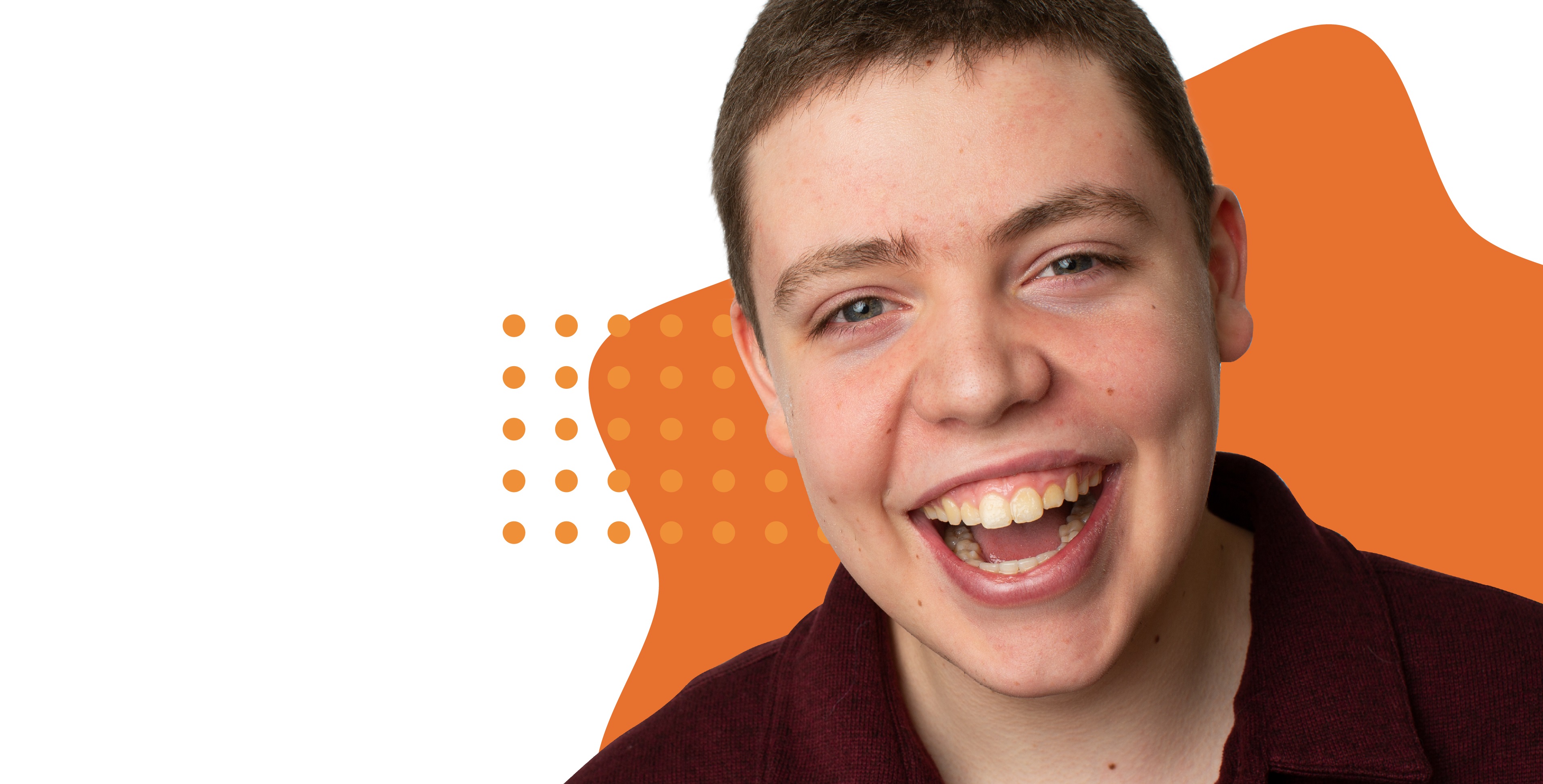 Adolescent white male with a disability smiling in front of a white and orange illustrated abstract background.