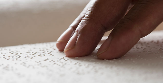 Fingers on braille paper